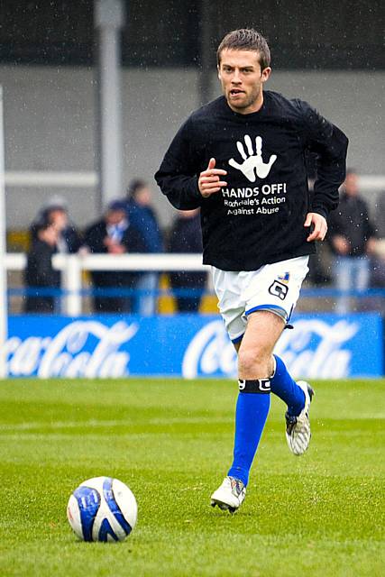 Defender Tom Kennedy shows his support for the Hands Off! campaign by wearing a branded t-shirt