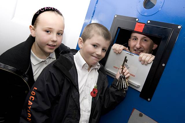 PC Rob Smiths in the cells with Elmwood pupils looking on and PCSO Dominique Grimes. 
