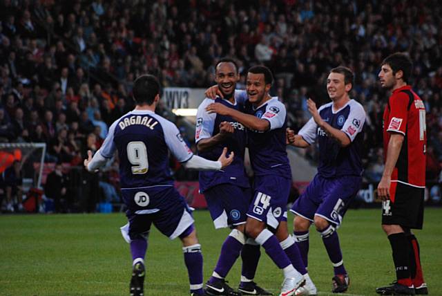 Rochdale players celebrate their fourth goal.