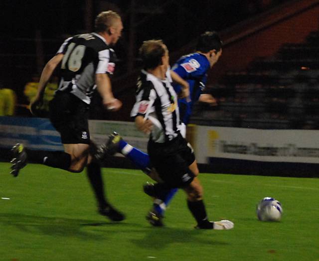 Chris Dagnall is sandwiched by two Notts defenders, he goes down and the referee awards a penalty.