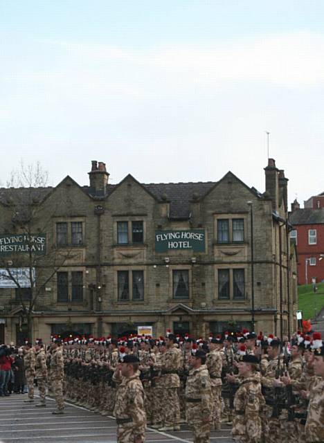 The Fusiliers present arms at the back of the town hall.