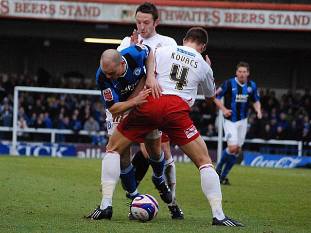 Gary Jones tries to wrestle his way past Janos Kovacs.