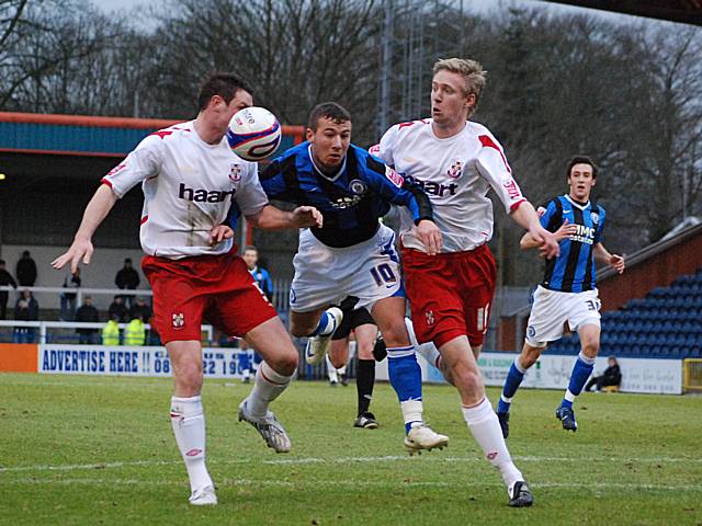 Le Fondre tries to squeeze his way between two Lincoln defenders.