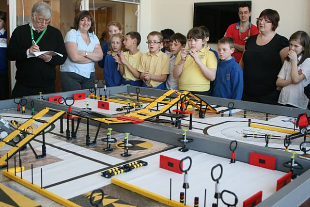 Teams gather around the table to watch others competiting