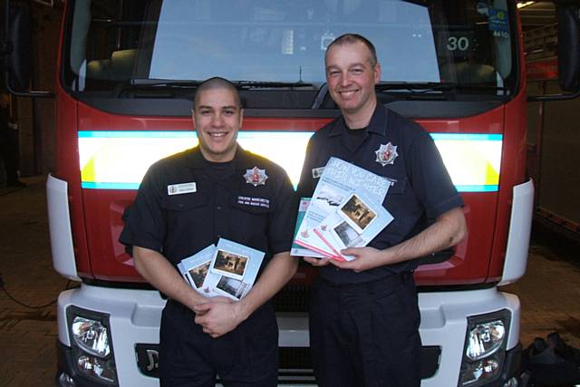 Firefighters Kris Ahmed and Chris Robinson with 'safe for winter' Christmas cards and posters.