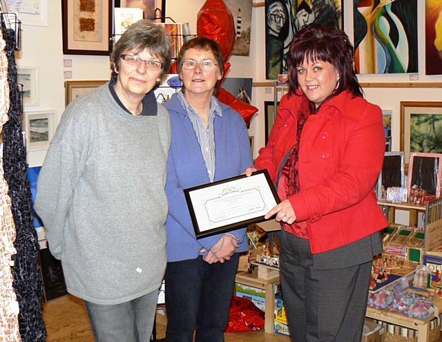 Chris and Angela from Number Ten are presented with their certificate by Debbie O'Brien, Rochdale Town Centre manager.