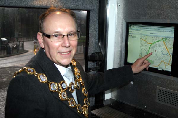 The Mayor points out Rochdale on a internet map using a computer on the bus