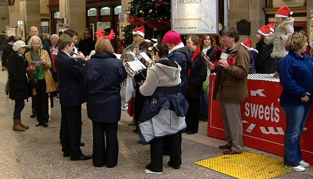 Passengers are greeted by the Littleborough band and carol singers at Manchester Victoria 
