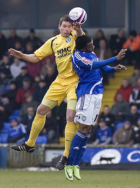 Toner wins a header against Izak Reid.