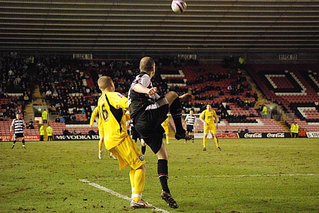 Austin hooks clear under pressure from Nicky Adams.