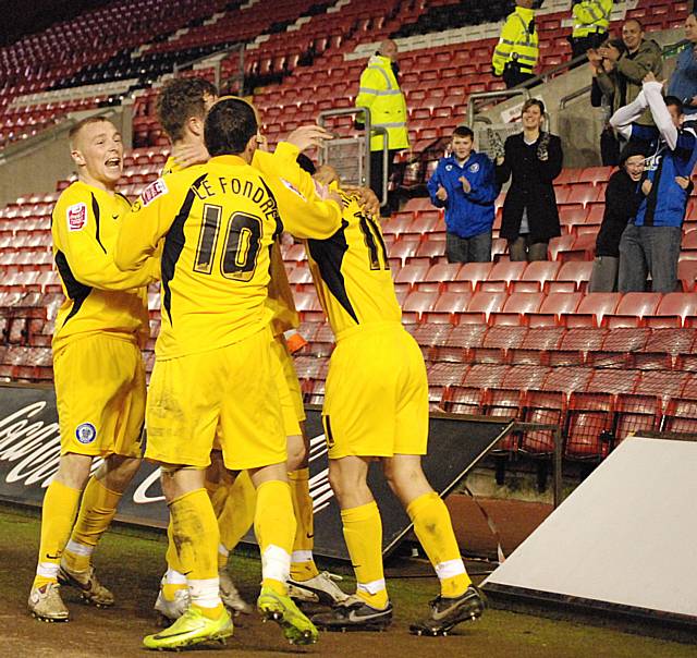 Rundle is mobbed by his team mates as Dale fans celebrate.