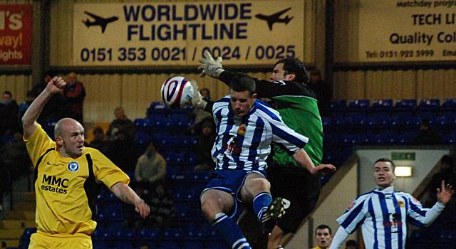 John Danby collides with his own defender while punching the ball clear.