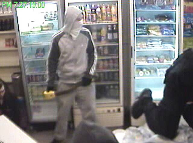 CCTV still showing one of the masked robbers armed with a crook lock.