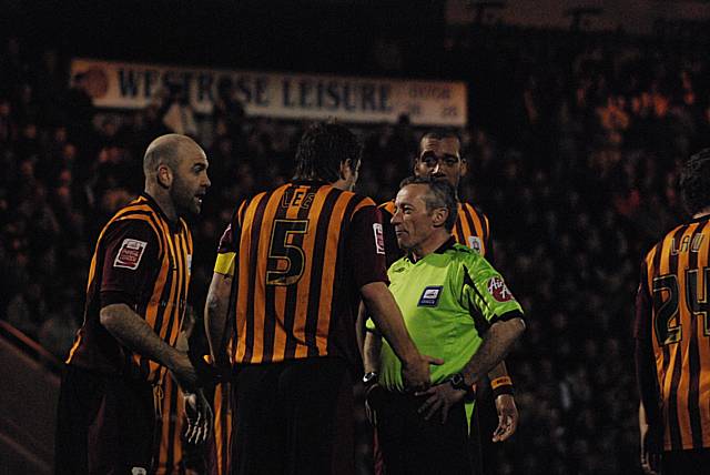 Bradford players surround the referee after he awards Dale's first penalty for handball.