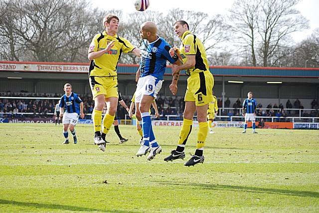 Lee Thorpe goes up for another header sandwiched between two defenders.