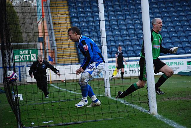 Andy Warrington makes a low save and denies Higginbotham a chance from the follow up.