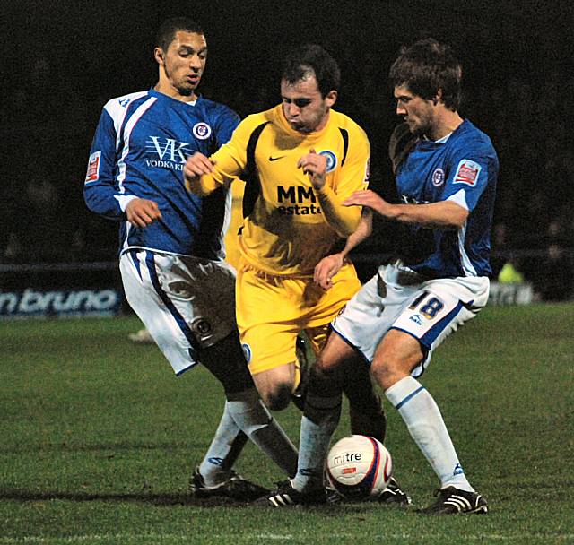 Dagnall tries to force his way between Montrose and Hall.