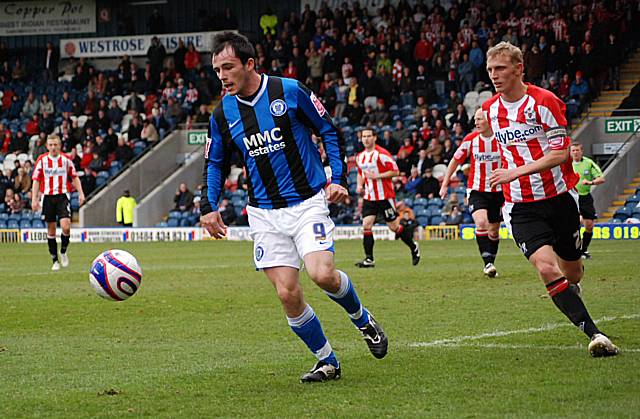 Chris Dagnall gathers the ball with his back to goal.