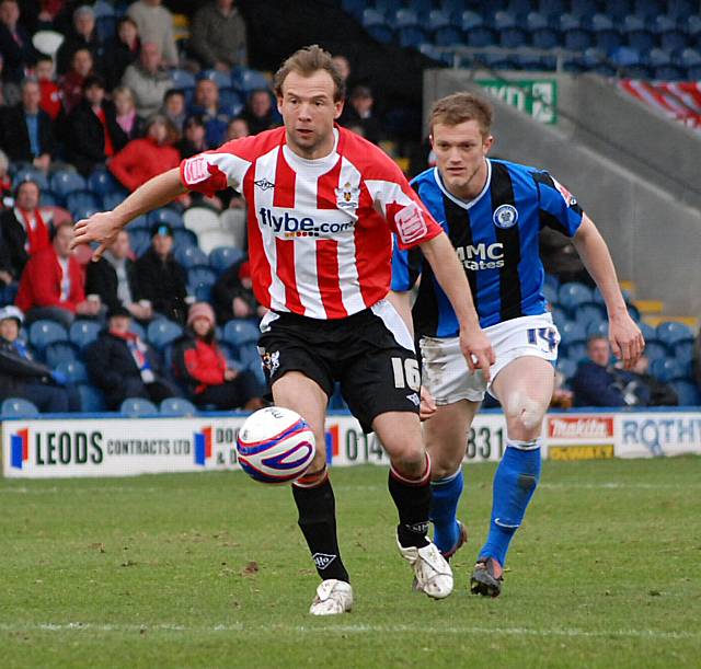 Exeter's two goal hero Stewart looks to clear his lines.