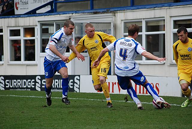 Steven Haslam hooks the ball clear from Adams and Le Fondre.