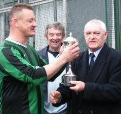 Bricklayers defender Darren Wright is presented with the Denis John Trophy by Rochdale & District Sunday Football League chairman Trevor Jones.