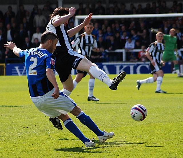 Ramsden clears the ball away from Dodds.