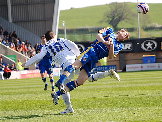 Kelvin Langmead heads the ball out of Le Fondre's path.