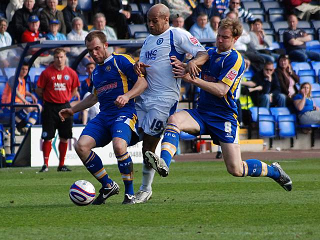 Lee Thorpe is sandwiched between two Shrewsbury defenders.