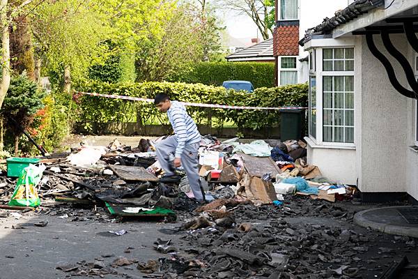 Devastated: Young Rehan looks through the rubble outside his house