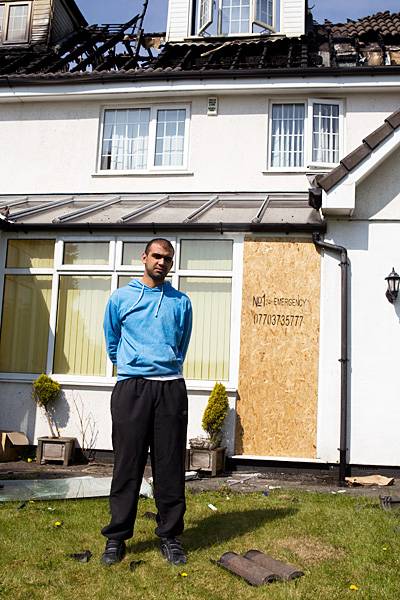 Gutted: Zeeshan stands outside the house he escaped from with his brother