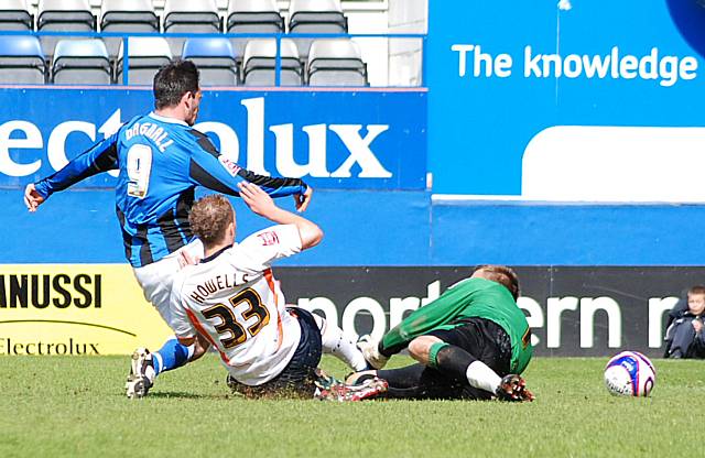 Dagnall is unable to slide the ball into the Luton net as Dean Brill and Howells close him down.