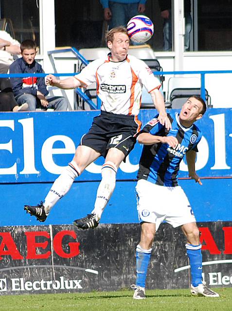 Livermore rises above Simon Ramsden to head the ball on.