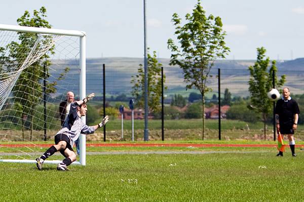 Lee Leonard's penalty on its way in despite the Copperpot keeper diving the right way