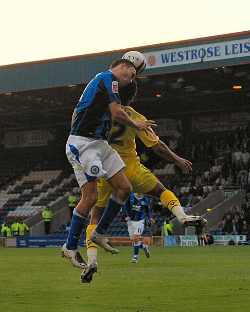 Ramsden wins a header against Barcham.