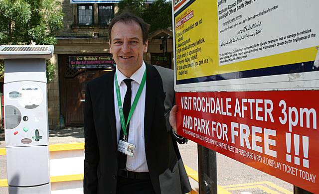 Councillor Greg Couzens next to one of the signs indicating free parking after 3pm.