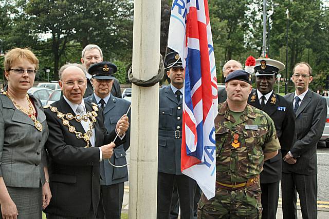 Servicemen and councillors join Mayor Keith Swift and Mayoress Sue Etchells to raise the flag.