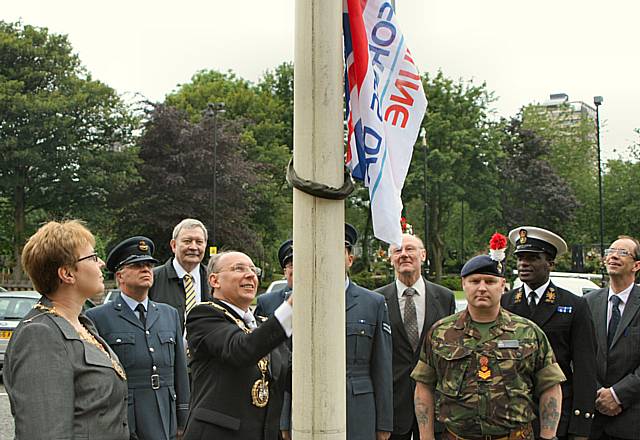 Mayor Swift raises the flag.