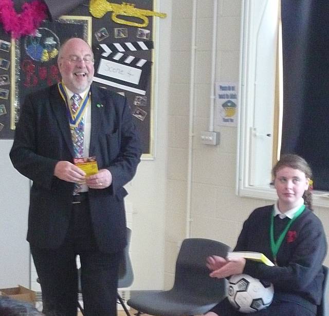 Rotarian John Kay presents the dictionaries to children at Redwood School.