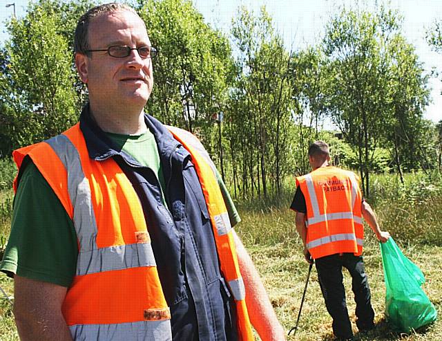 Community Payback Supervisor, Neil McLaren overseeing offenders working to tidy up on  Whitworth Road.