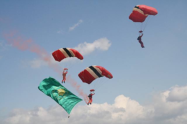 The Red Devils landing with the college flag