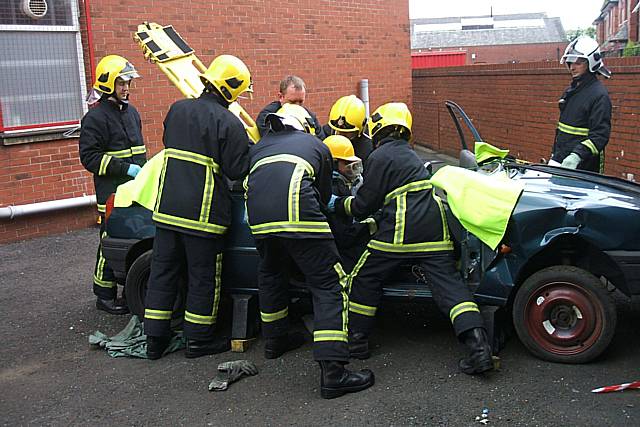 Fire fighters cut the young people out of a car in what could be a real-life situation