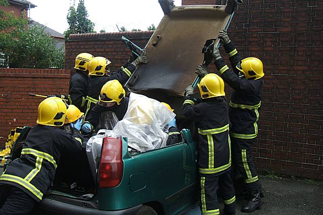 Fire fighters cut the young people out of a car in what could be a real-life situation