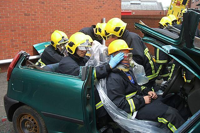 Fire fighters cut the young people out of a car in what could be a real-life situation