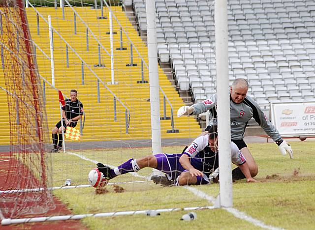 Dagnall beats Warrington to the ball and slides in to make sure it crosses the line.