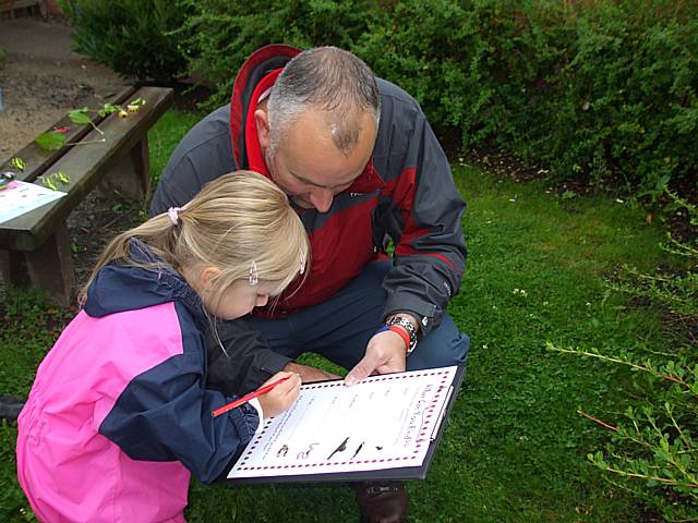 A father and daughter identify bugs at Meanwood Sure Start Centre.