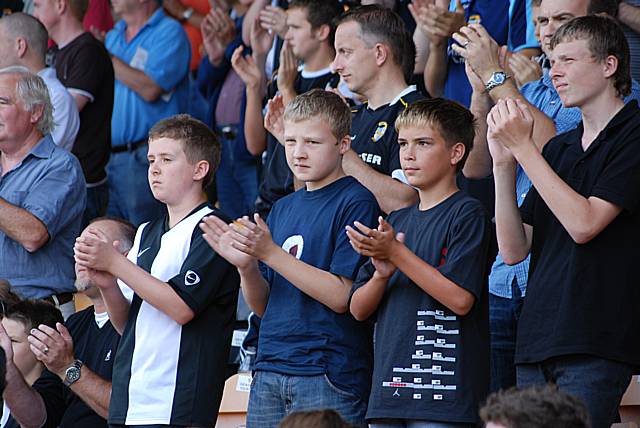 Young Port Vale fans applaud during the minute's celebration of Sir Bobby Robson's life.