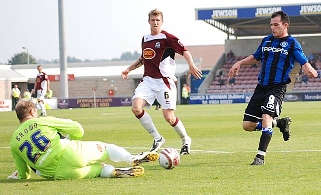 Simon Brown gathers the ball in front of Chris Dagnall.