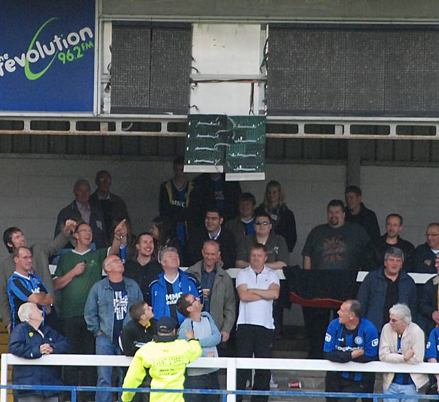 Amusement among the Dale supporters after a clearances causes damage to the scoreboard.