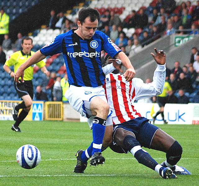 Efe Sodje tackles Chris Dagnall on the edge of the Bury box.