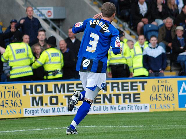 Tom Kennedy holds his ear to the Bury fans after scoring his penalty; a celebration that sparked controversy.